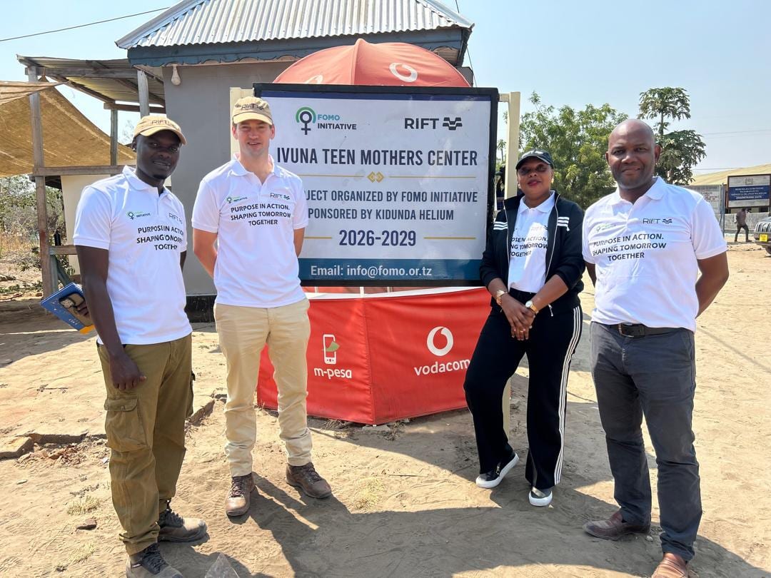 The delegation gathered at the Ivuna Teen Mothers Centre signboard