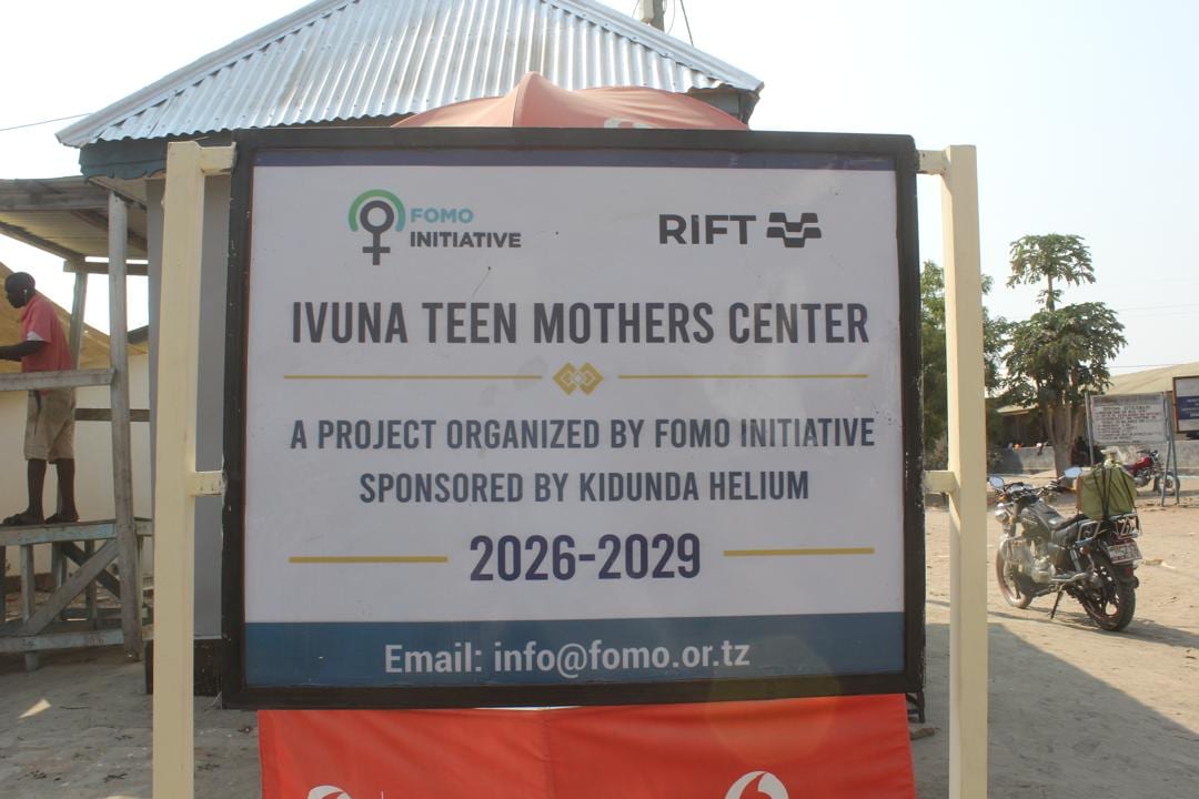 The Ivuna Teen Mothers Centre signboard, naming FOMO Initiative as organiser and Kidunda Helium as sponsor, 2026 to 2029