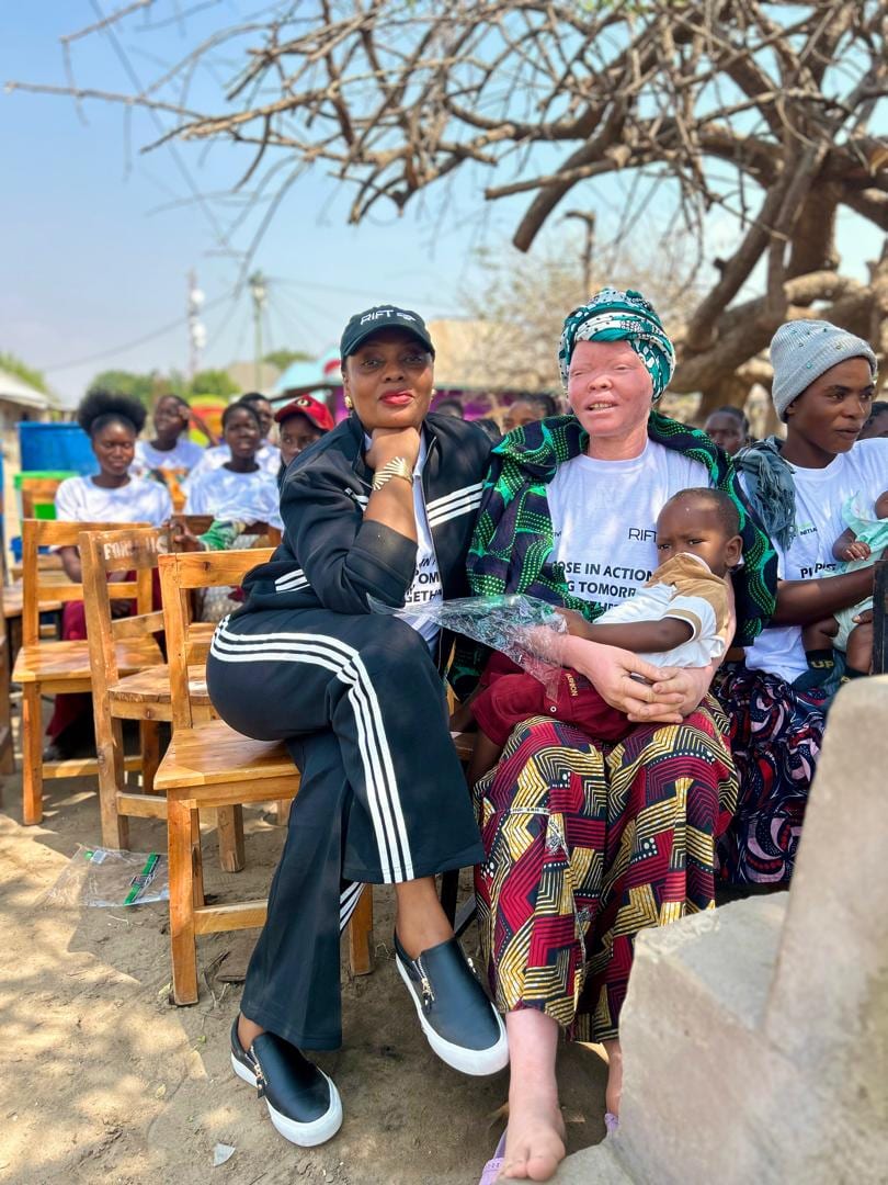 Vivian Sirikwa seated beside a programme participant holding her child at the launch